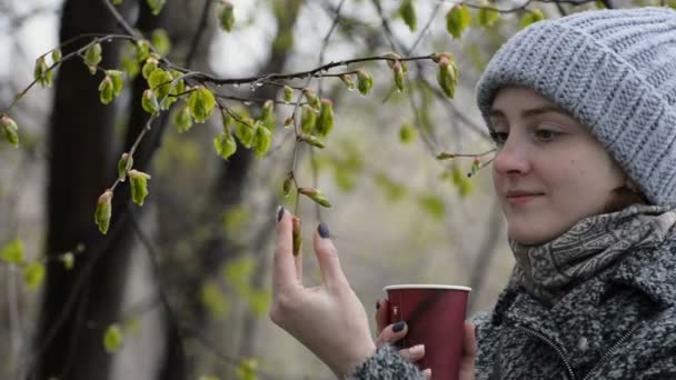 Молодая Женщина Касается Молодых Цветущих Зеленых Листьев Влажный Снег — стоковое видео