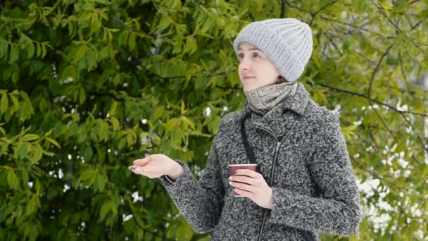 Молодая Женщина Шляпе Бумажной Чашкой Руках Ловит Снег — стоковое видео