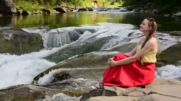 Красива Довгошерста Дівчина Червоній Спідниці Сидить Скелі Фоні Гірського Річкового — стокове відео