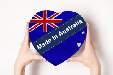 Yazıt Avustralya'da Avustralya bayrağı made. Kalp şeklinde bir kutu tutan kadın elleri. Beyaz arka plan.