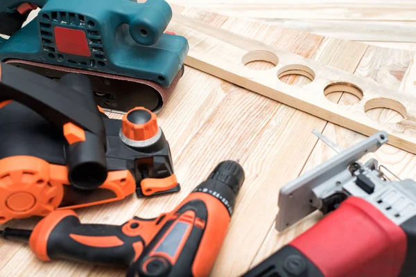 Ahşap işleme ve iş parçası için el ahşap elektrikli el aletleri seti hafif ahşap arka plan üzerinde yatıyor. Yakın çekim