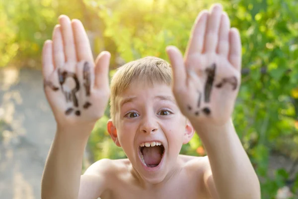 Lachende jongen met verhoogde handen geschreven vraag en uitroeptekens. Zomer achtergrond — Stockfoto