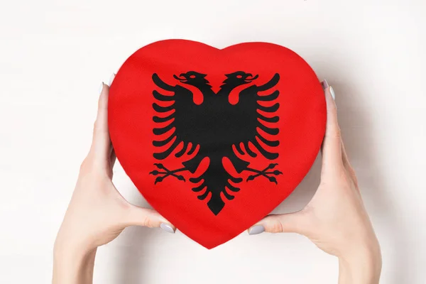 Bandera de Albania en una caja en forma de corazón en manos femeninas. Fondo blanco —  Fotos de Stock