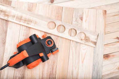 Elektrikli uçak ve iş parçası açık kahverengi ahşap bir masa üzerinde yatıyor. Ahşap. Doğrudan yukarıda, kopyalama alanı.