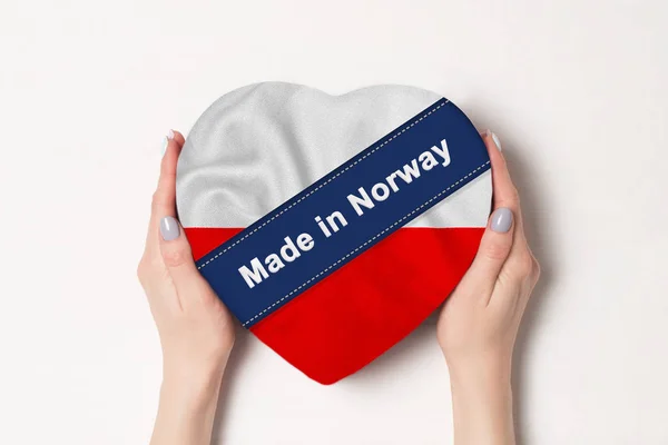 Inscripción Hecho en Polonia la bandera de Polonia. Manos femeninas sosteniendo una caja en forma de corazón. Fondo blanco . —  Fotos de Stock