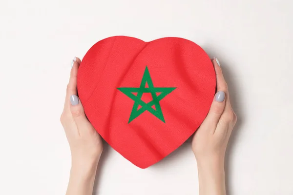 Bandera de Marruecos en una caja en forma de corazón en manos femeninas. Fondo blanco — Foto de Stock