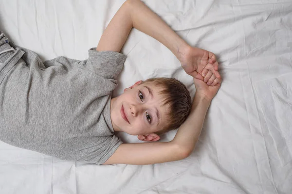 Sonriente niño acostado en la cama. Vista superior, espacio de copia . —  Fotos de Stock