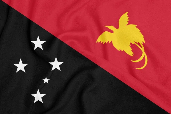 Bandera de Papua Nueva Guinea sobre tela texturizada. Símbolo patriótico — Foto de Stock