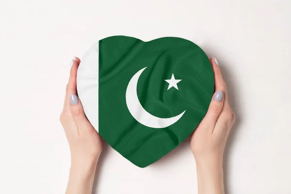 Σημαία του Πακιστάν σε ένα κουτί σε σχήμα καρδιάς σε γυναικεία χέρια. Λευκό φόντο — Φωτογραφία Αρχείου