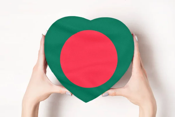 Σημαία του Μπανγκλαντές σε ένα κουτί σε σχήμα καρδιάς σε γυναικεία χέρια. Λευκό φόντο — Φωτογραφία Αρχείου