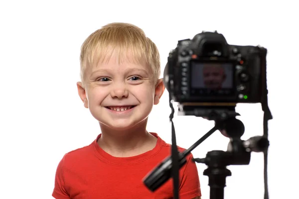 카메라 렌즈 앞에서 웃고있는 금발 소년. 작은 비디오 블로거. 흰색 배경 — 스톡 사진