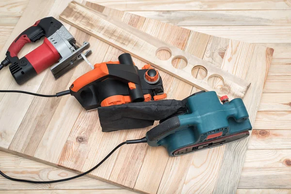 Ahşap ve iş parçası için el ağaç işleme elektrikli aletler seti açık tahta arka planda yatıyor.