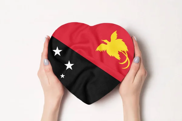 Bandera de Papúa Nueva Guinea en una caja en forma de corazón en manos femeninas. Fondo blanco — Foto de Stock