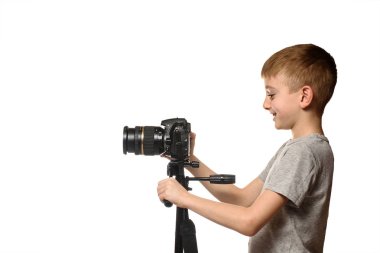 Schoolboy Dslr kamera video çekiyor. Yan görünüm. Beyaz arka plan, izole