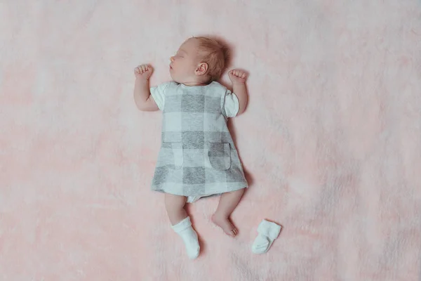 Sleeping newborn girl in a dress on a pink blanket. Top view. Space for text — Stock Photo, Image