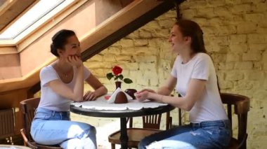 İki güzel kız bir kafede sohbet ediyor. Gün ışığı