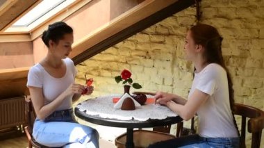 İki güzel kız bir kafede sohbet ediyor. Gün ışığı