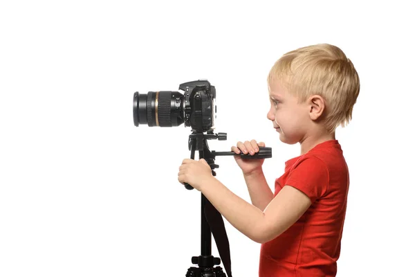 Blond chłopiec strzela wideo na DSLR Camera. Widok z boku. Białe tło, izolowanie — Zdjęcie stockowe