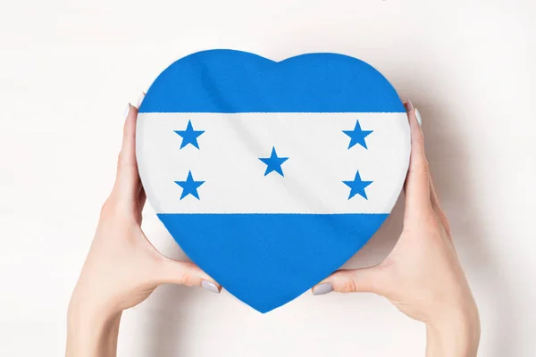 Vlag van Honduras op een hartvormige doos in een vrouwelijke handen. Witte achtergrond — Stockfoto