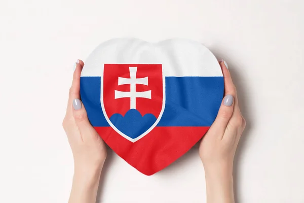 Slovakiens flagga på en hjärtformad låda i en kvinnlig händer. Vit bakgrund — Stockfoto