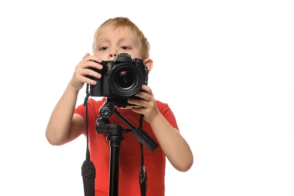 ブロンドの男の子は一眼レフカメラで写真を撮ります。正面図。白い背景, 分離 — ストック写真