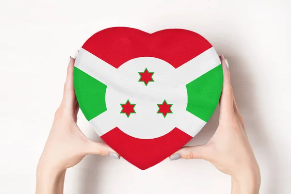 Drapeau du Burundi sur une boîte en forme de cœur dans une main féminine. Fond blanc — Photo