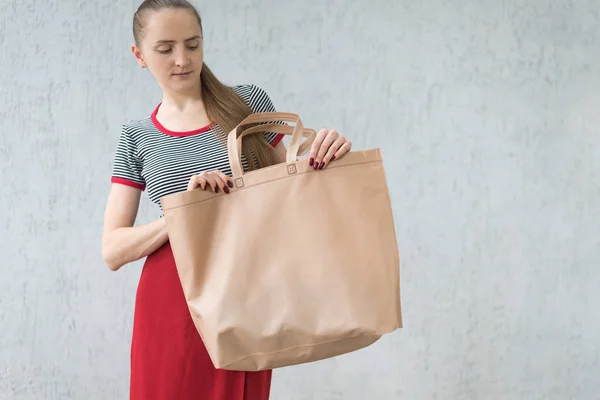 Large eco shopping bag in the hands of a young woman. Design space — Stock Photo, Image