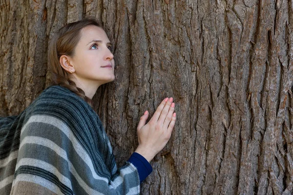 La joven se apoyó en el tronco de un gran árbol. Unidad con la naturaleza — Foto de Stock