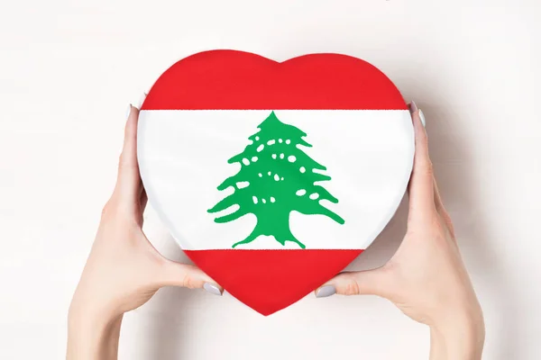 Bandera del Líbano en una caja en forma de corazón en manos femeninas. Fondo blanco — Foto de Stock