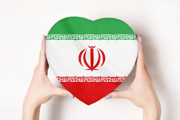 Bandera de Irán en una caja en forma de corazón en manos femeninas. Fondo blanco — Foto de Stock