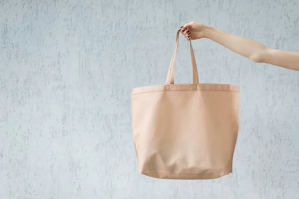 Gran bolsa eco en la mano de una mujer joven. Copiar espacio. Fondo blanco —  Fotos de Stock