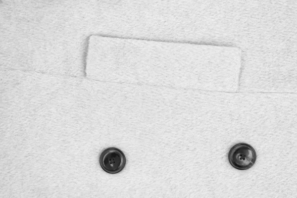 Weißes texturiertes Wollmantelgewebe mit einer Reverentasche und zwei Knöpfen. Nahaufnahme — Stockfoto