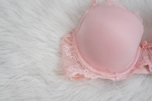 Dettaglio di corpetto rosa dlicate con pizzo su pelliccia bianca. Biancheria intima, concetto di moda. Da vicino. — Foto Stock