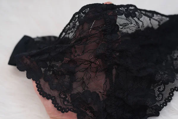 Lacy calcinha preta na mão feminina. Fecha. Conceito na moda de lingerie — Fotografia de Stock