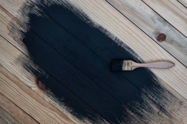 Kısmen tahta tahtaları siyaha boyamış. Kirli fırça, işlem. Bitmemiş bir iş. Metin için boşluk