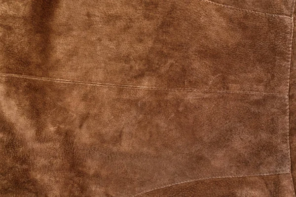 Part of brown textured suede clothing. Genuine leather