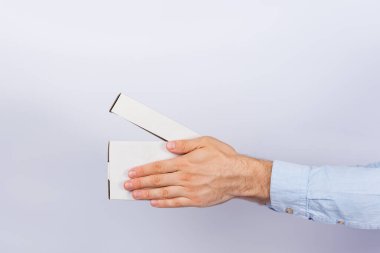 Erkeklerin elleri beyaz arka planda açık kutuyu tutuyor. Paketleri güvenli bir şekilde teslim et. Yan görünüm.