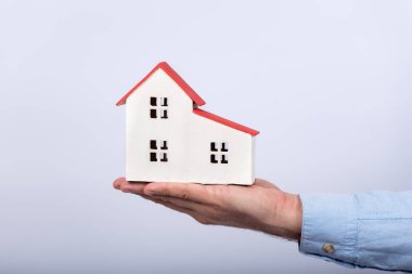 Beyaz arka planda bir ev modeli. Kendi ev konseptini al.