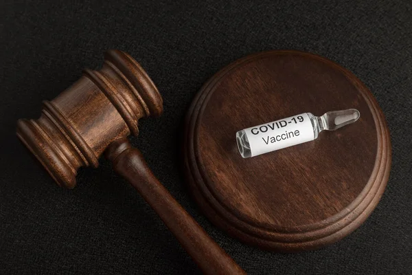 Yargıç tokmak ve cam ampul şişesinde koronavirüs COVID-19 aşısı var. Covid-19 'a karşı kavram yasaları