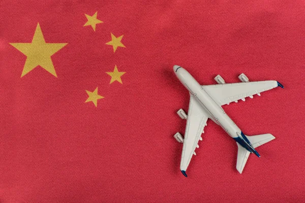 Flag of Peoples Republic of China and model airplane. Flights to China after quarantine. Resumption of flights.