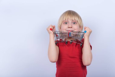 Çocukların elinde iki oyuncak alışveriş arabası var. Beyaz arka planda alışveriş arabasıyla oynayan çocuk.