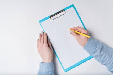 Belge üzerinde kalem olan kadın eller. Kadın kağıda imza atıyor. Üst görünüm.