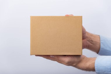 Erkeklerin elinde kare karton kutu. Paketlerin teslimatı. Yan görünüm