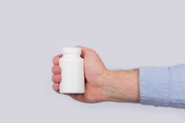 Erkek el, plastik hap şişesini tutuyor. Kapatın. Uzayı kopyala Şablon. Model.