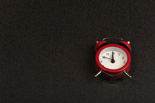 Vintage mechanical alarm clock on black background. Time to. Copy space.