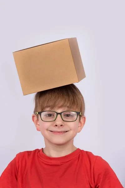 Menino Camisa Vermelha Óculos Sorrindo Segurando Caixa Papelão Cabeça Quadro — Fotografia de Stock
