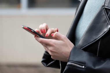 Elinde cep telefonu olan genç bir kadın. Akıllı telefonlu bir iş kadını..