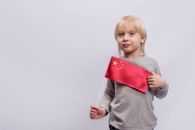 Yakışıklı sarışın çocuk elinde Çin bayrağı tutuyor. Çin 'deki eğitim. Çince öğrenmek.