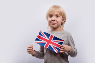 İngiliz bayrağı taşıyan heyecanlı, sarışın çocuk. Çocuklar için İngilizce öğreniyorum. Birleşik Krallık 'ta Eğitim