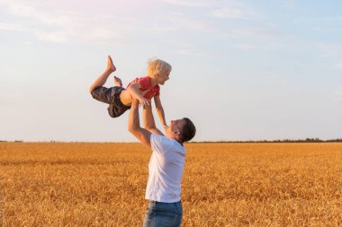 Babam oğlunu kollarına atıyor. Baba ve çocuk eğleniyor. Mutlu babalar.